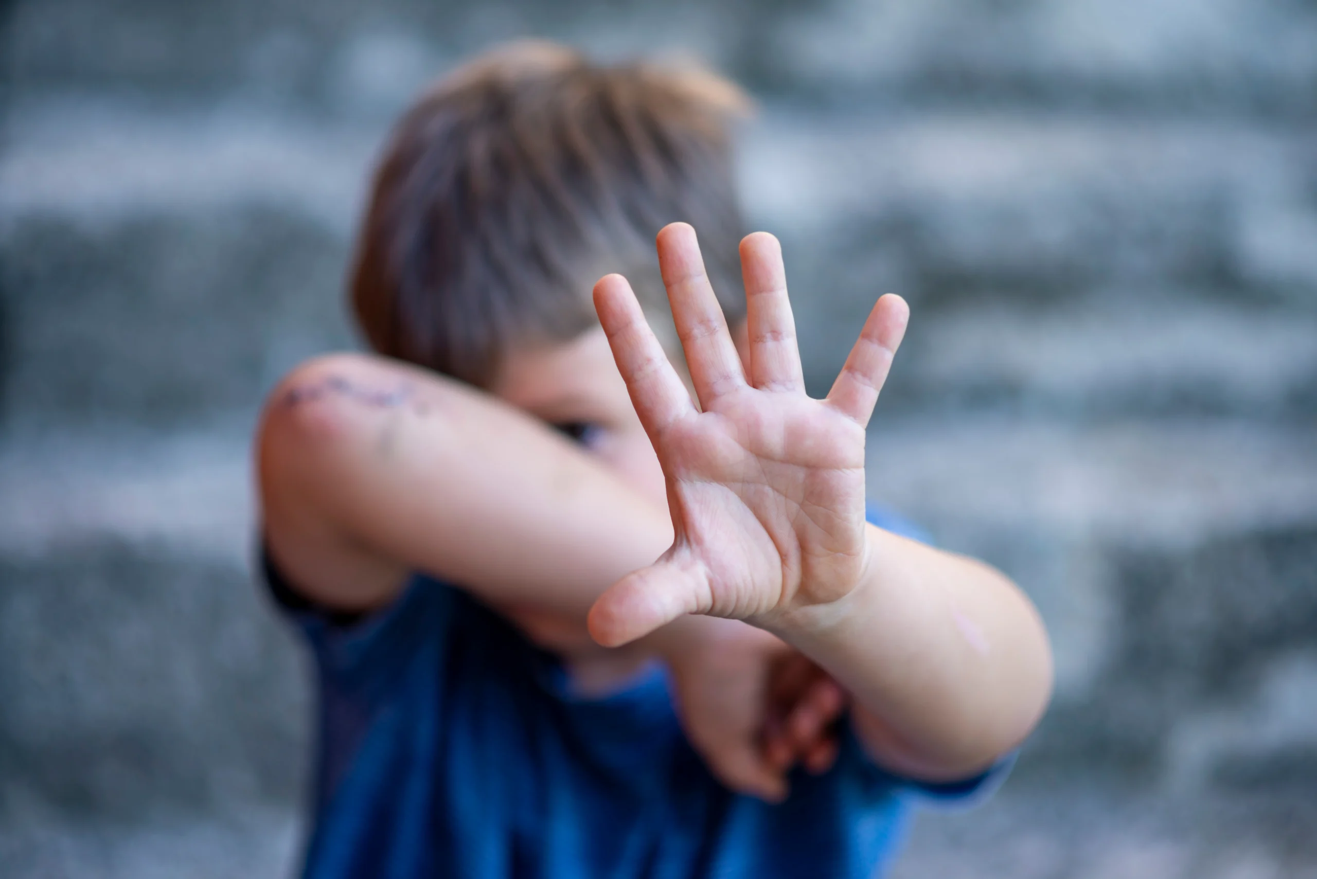 Niño con expresión de miedo, representando el maltrato infantil y la violencia en el hogar.